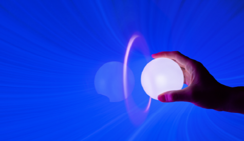 Mano sosteniendo una esfera luminosa blanca sobre fondo azul con efectos de luz radiante, simbolizando innovación, energía y tecnología futurista.